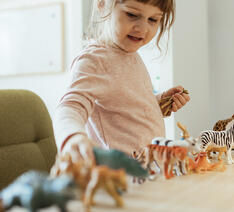 Pige leger med plastik legetøj