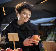 Anja Philip holder et æble på et marked
