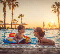 Mor med søn på ferie i en pool