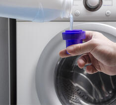 Mand vasker tøj med flydende vaskemiddel