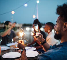 Mand tager foto med smartphone til en fest med venner