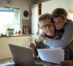 To ældre mennesker kigger på deres økonomi