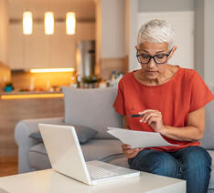 kvinde kigger på din private pensionsopsparing på sin computer i stuen