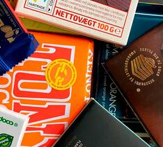 Pakker med chokolade fra flere mærker der har forskellige etiske eller miljøvenlige mærker på.