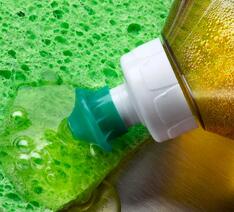 Opvaskemiddel til håndopvask uden uønsket kemi hældes på en svamp