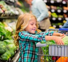 Barn bestemmer hvad der skal i indkøbsvognen i et supermarked.