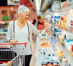 Kvinde kigger på dagligvarer i supermarked