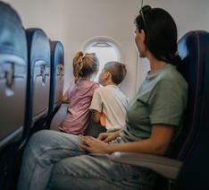 mor og to børn i flyvemaskine