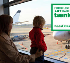 Mor og barn i Københavns Lufthavn med fly i baggrunden
