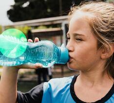 girl drinking from drinking bottle