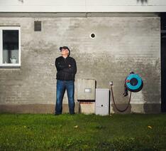 Totalfoto af Bjarne Andersen, der står foran sit hjem