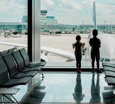 To børn venter på et forsinket eller aflyst fly i en lufthavn