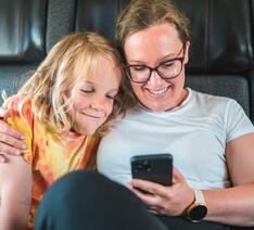 Mor og søn kigger på mobiltelefon