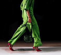model på catwalk i grønt tøj går mod højre