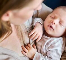 Kvinde med spædbarn i armene