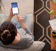 kvinde i sofa med telefon