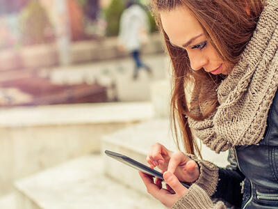 pige kigger på smartphone og skal undgå falske brugeranmeldelser