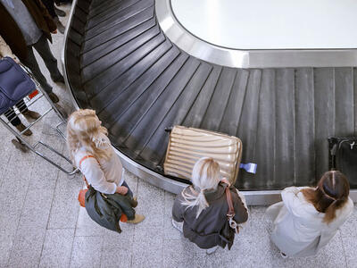 Personer venter på deres bagage i lufthavnen