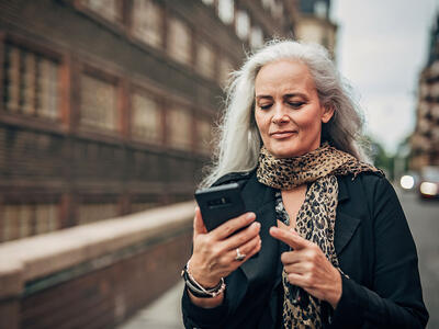 Kvinde kigger på sin telefon fordi hun har modtaget en svindelbesked