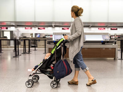 Kvinde med en klapvogn i en lufthavn