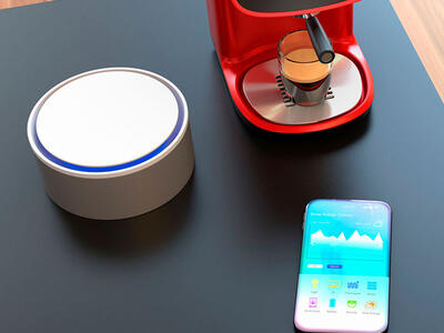Smartphone og højtaler på bord der kan forbinde trådløst ved enten Wifi eller Bluetooth
