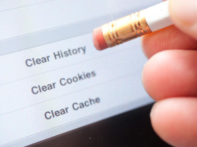 En person bruger sin blyant til at trykke på en skærm og slette sin cookie historie på nettet