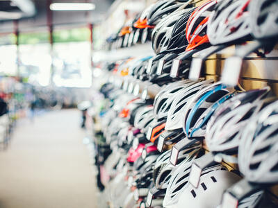 Cykelhjelme på lang række i butik