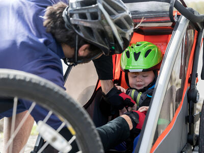 Barn sættes i anhænger til cykel