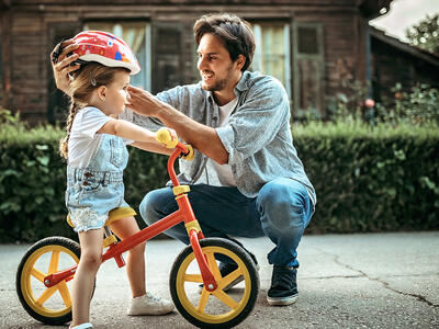Få gode råd når du skal købe løbecykel - mand med barn og løbecykel