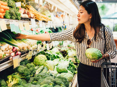 kvinde kigger på grøntsager i supermarkedet.