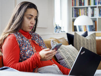 Kvinde med telefon og computer