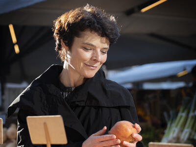 Anja Philip holder et æble på et marked