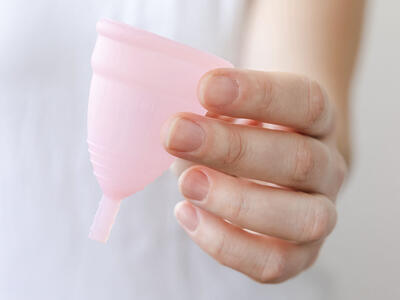 Kvinde holder en menstruationskop