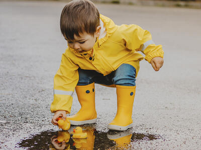 Dreng med gummistøvler på i regnen