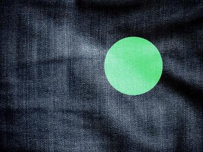 Nærbillede af mørk denim med en grøn cirkel på