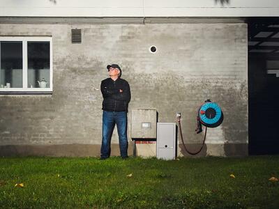Totalfoto af Bjarne Andersen, der står foran sit hjem