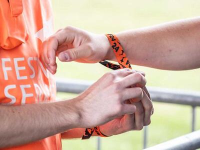 En festivalgæst får armbånd på til Roskilde Festival 2024