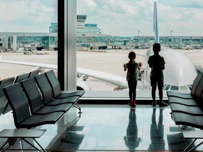To børn venter på et forsinket eller aflyst fly i en lufthavn