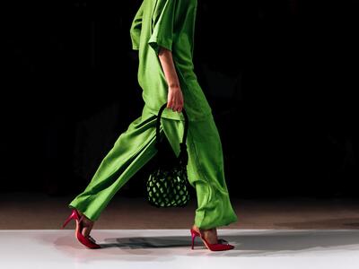 model på catwalk i grønt tøj går mod højre
