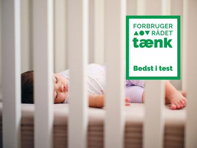 Barn sover på madras i tremmeseng - illustrerer test af babymadrasser