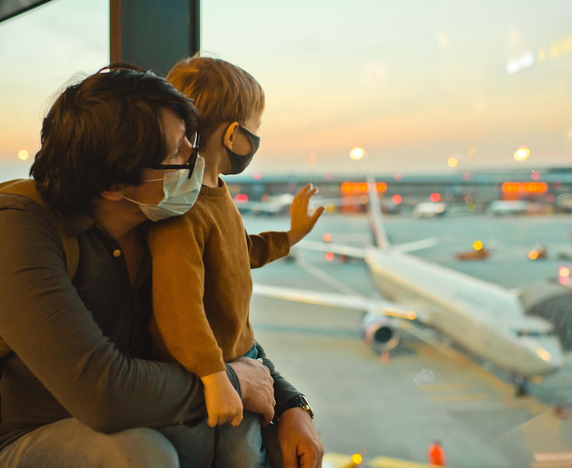 Far og søn i lufthavn ser ud på flyene