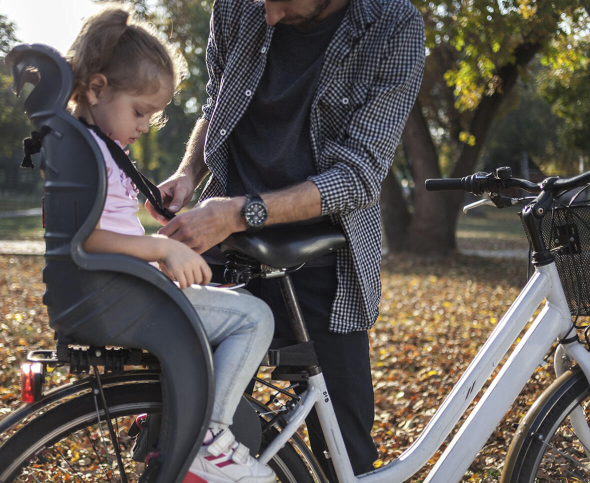 Far spænder datter fast i cykelstol