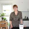 Halvnær af Katja, der står i sit køkken med en blender